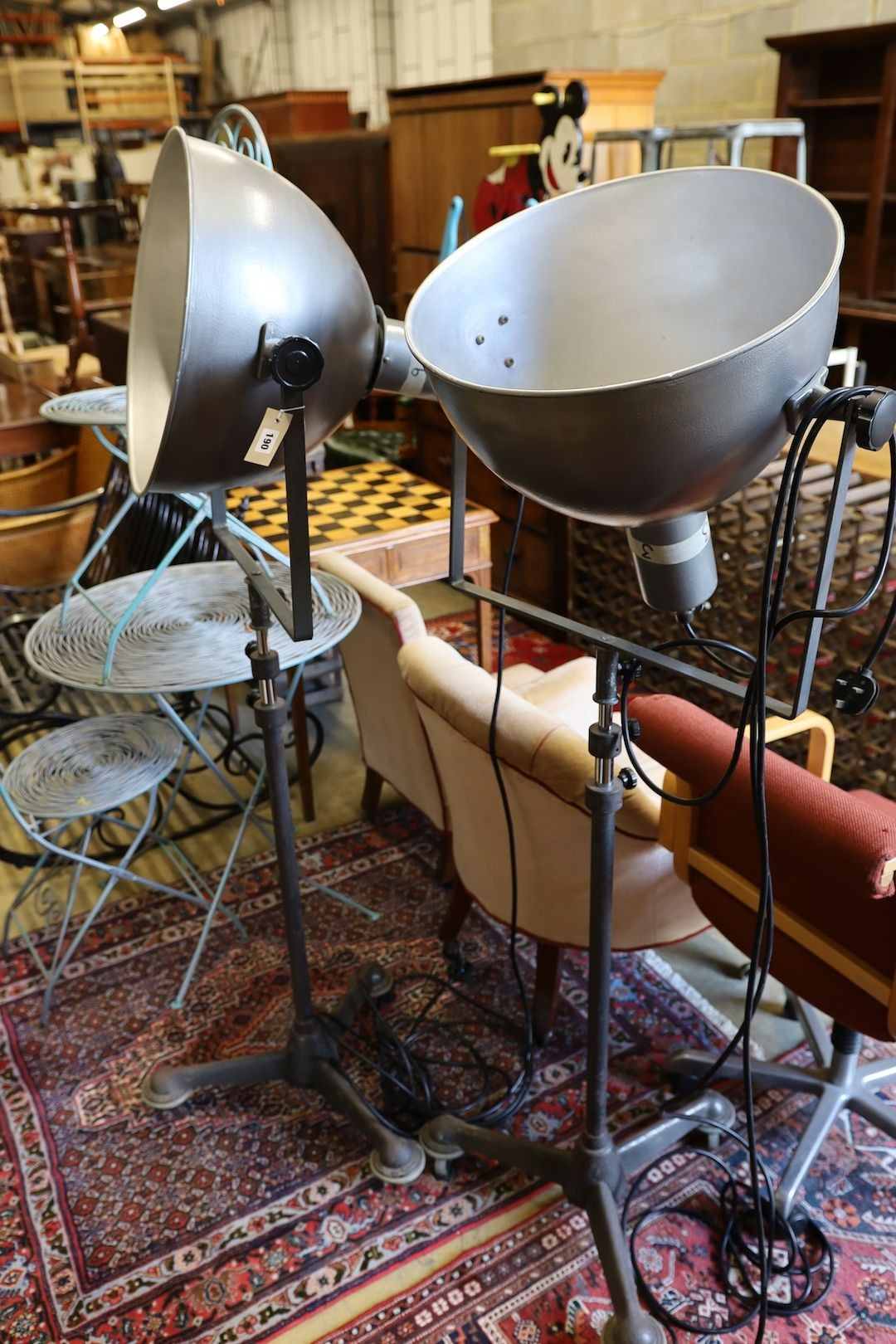 A pair of industrial style theatre lights on telescopic stands (reputedly from The Strand, London), shade diameter 48cm